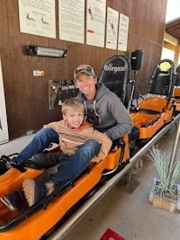 a man and a child on a sled at a park